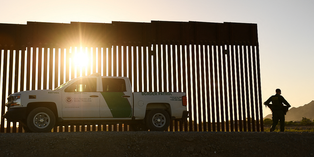 Un agente de la Patrulla Fronteriza camina entre una brecha a lo largo del muro fronterizo entre Estados Unidos y México en Yuma, Arizona, el 1 de junio de 2022.