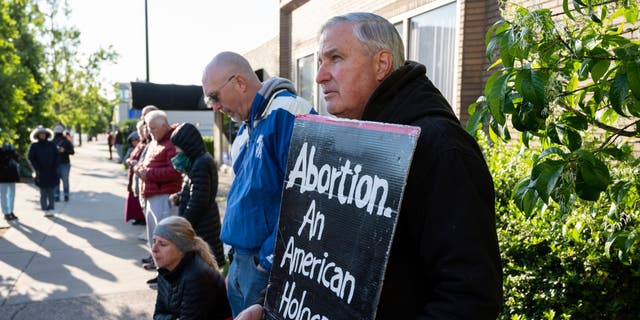 Un manifestante provida se para con su pancarta frente a EMW Women's Surgical Center, una clínica abortista, el 8 de mayo de 2021, en Louisville, Kentucky.