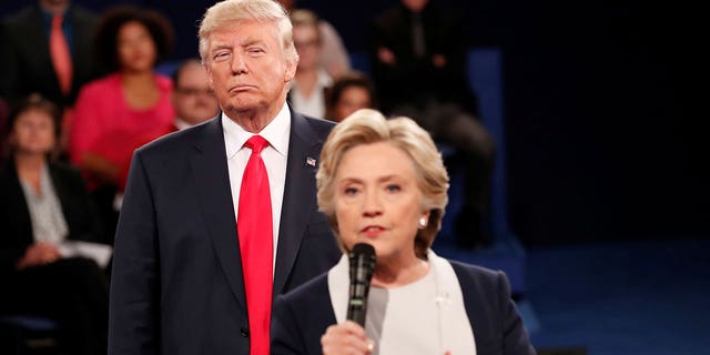 El candidato republicano a la presidencia de Estados Unidos, Donald Trump, escucha mientras la candidata demócrata, Hillary Clinton, responde a una pregunta del público durante su debate presidencial en la Universidad de Washington en St. Louis, Missouri, Estados Unidos, 9 de octubre de 2016.