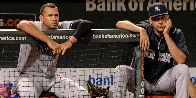 Alex Rodríguez # 13 (L) y Derek Jeter # 2 de los Yankees de Nueva York miran contra los Orioles de Baltimore en la novena entrada en el Oriole Park en Camden Yards el 11 de septiembre de 2013 en Baltimore, Maryland.