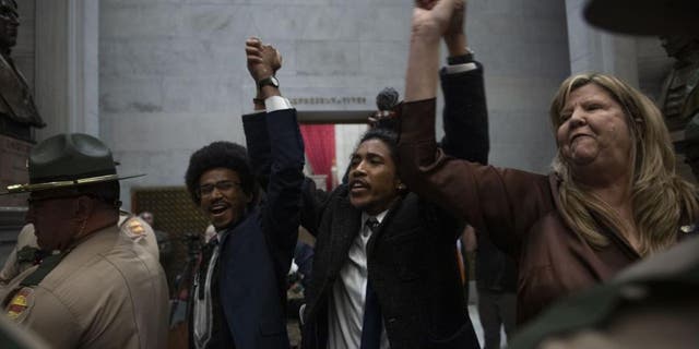 Rep. Justin Pearson, Rep. Justin Jones, Rep. Gloria Johnson La gente levanta las manos al salir de las puertas de la Cámara en Tennessee State Capitol Building en Nashville, Tennessee, Lunes, 03 de abril 2023. Los legisladores republicanos de Tennessee han dado los primeros pasos para expulsar a tres miembros demócratas de la Cámara dominada por el GOP por su papel en una reciente protesta por el control de armas en el Capitolio estatal.