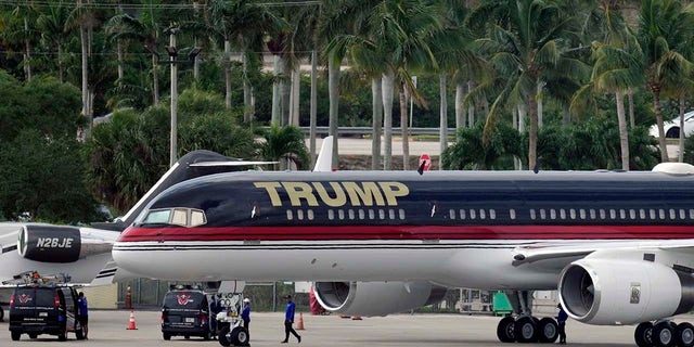 La gente trabaja alrededor del avión privado del ex presidente Donald Trump, ya que se encuentra estacionado en la pista en el Aeropuerto Internacional de Palm Beach, el lunes 3 de abril de 2023, en West Palm Beach, Florida. Se esperaba que Trump viajara más tarde en el día a la ciudad de Nueva York para su comparecencia después de ser acusado por un gran jurado de Manhattan.