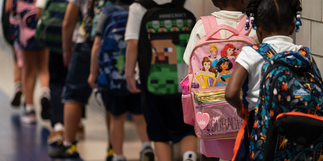 Niños con mochilas en la escuela